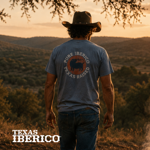 Man wearing a 'Pure Iberico Texas Raised' t-shirt in a desert landscape with 'Texas Iberico' branding.